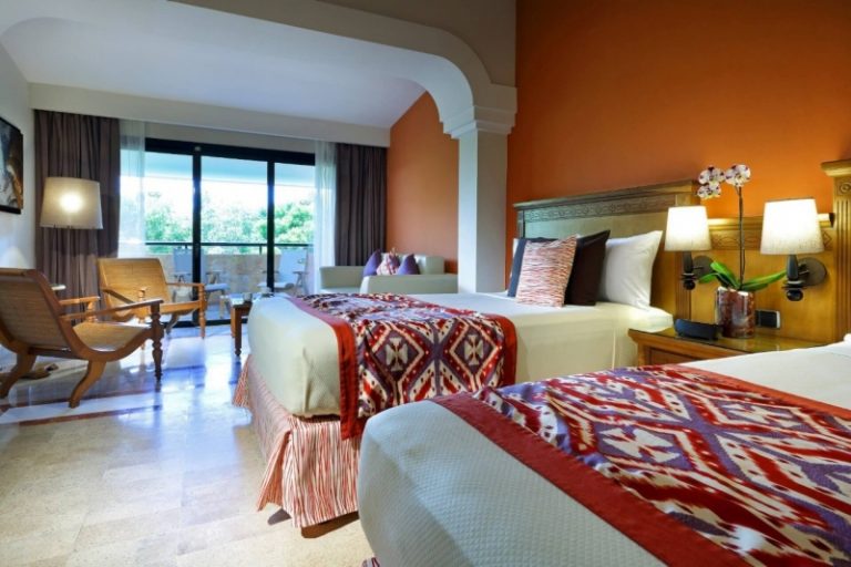 Habitación con cama de matrimonio y zona de estar del Grand Palladium Riviera Maya