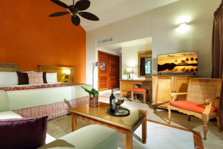 Habitación con cama, escritorio y butacas del Grand Palladium Riviera Maya