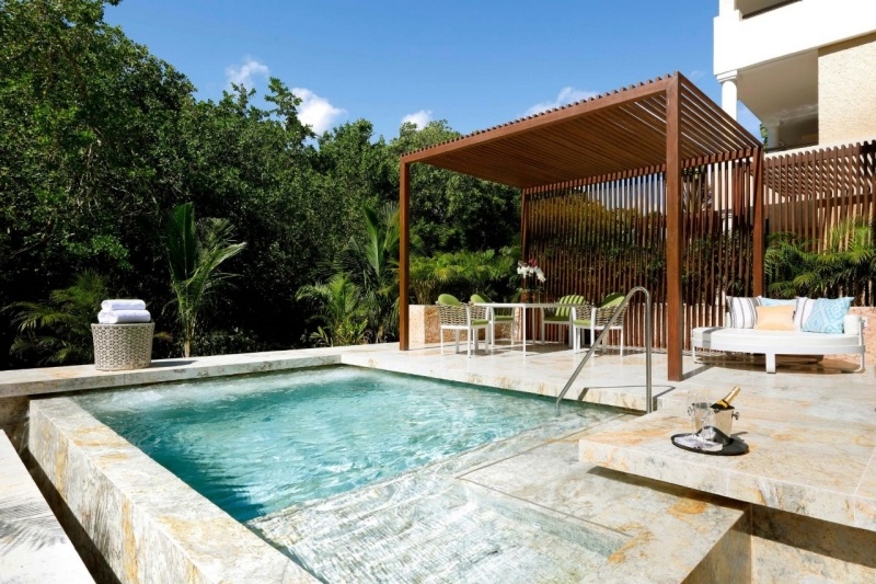 Piscina privada de una suite del TRS Yucatán, con pérgola de madera y la selva alrededor