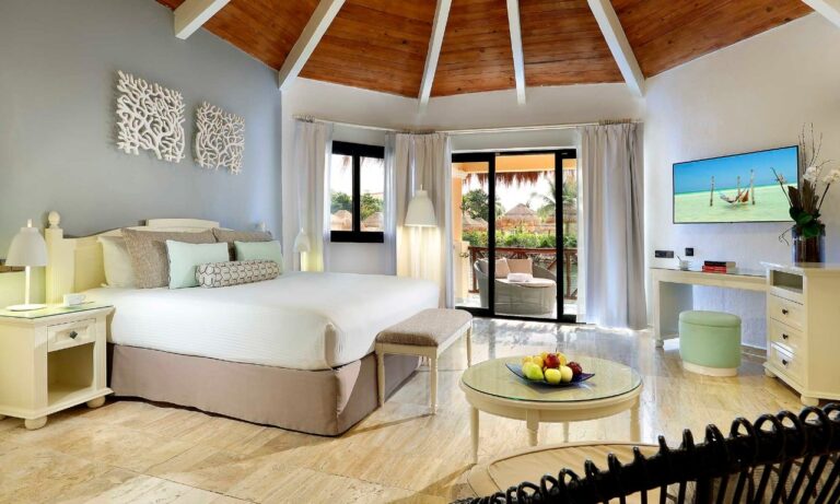 Dormitorio del Romance Bungalow del Grand Palladium White Sand con techo de palapa