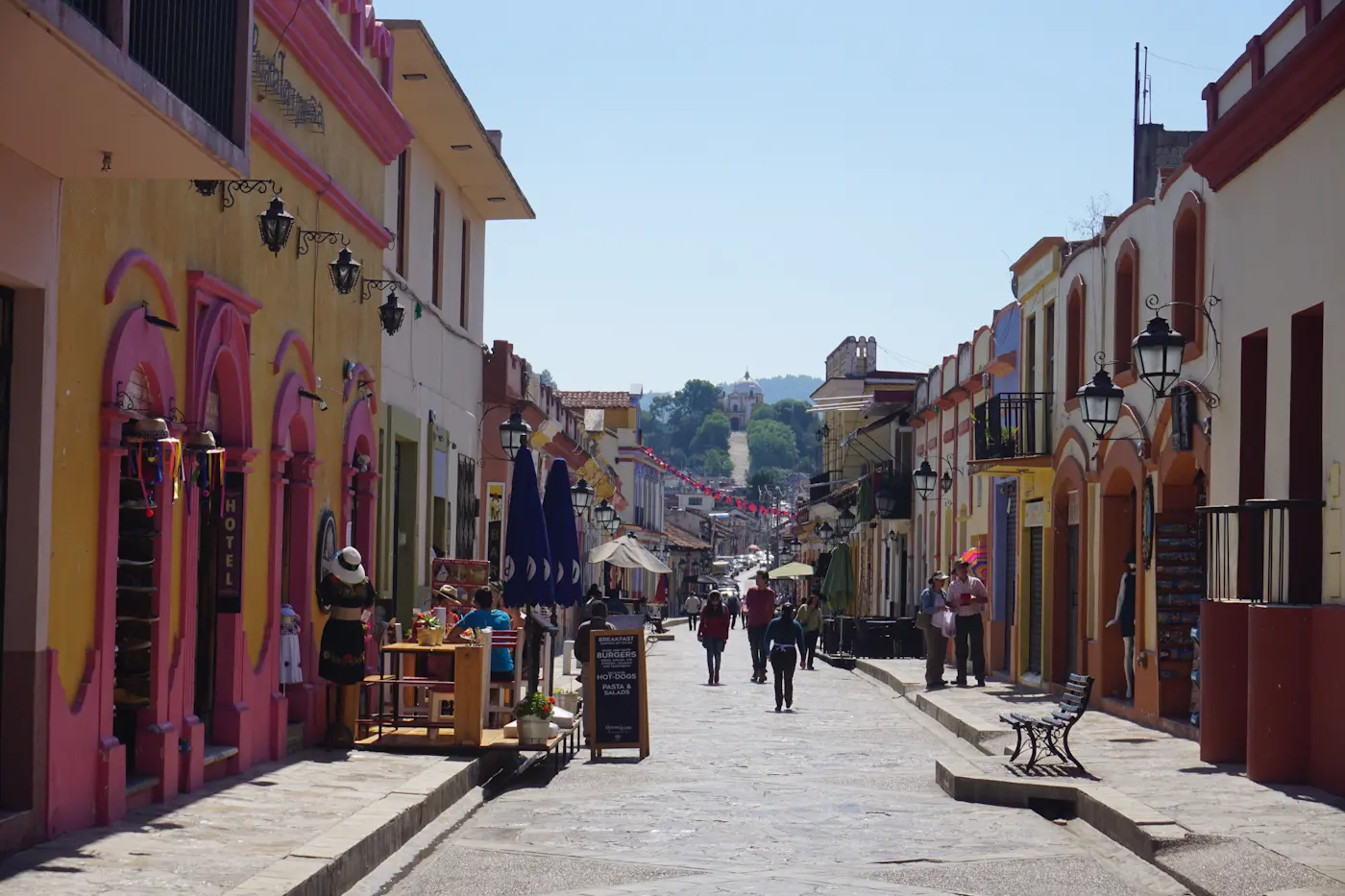Calle del centro histórico de San Cristóbal de las Casas, con casas de colores, faroles y la montaña al fondo