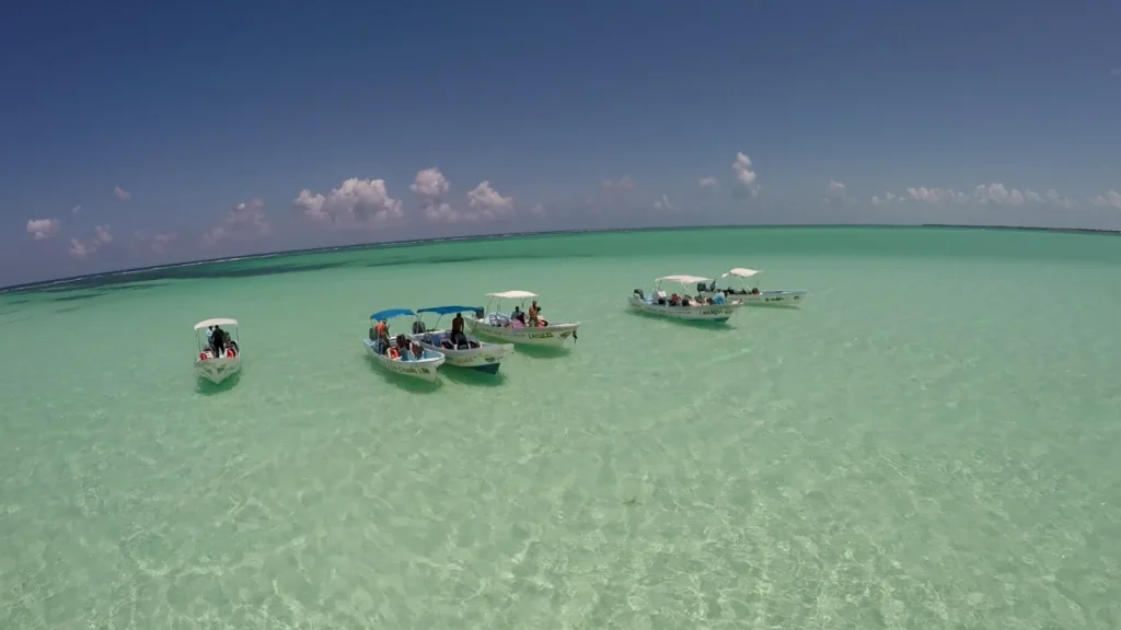 Barcas sobre el agua transparente de un banco de arena en la Riviera Maya