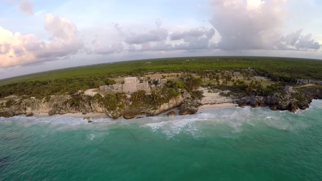 El castillo de Tulum sobre el acantilado y la cala de arena, vistos desde el aire
