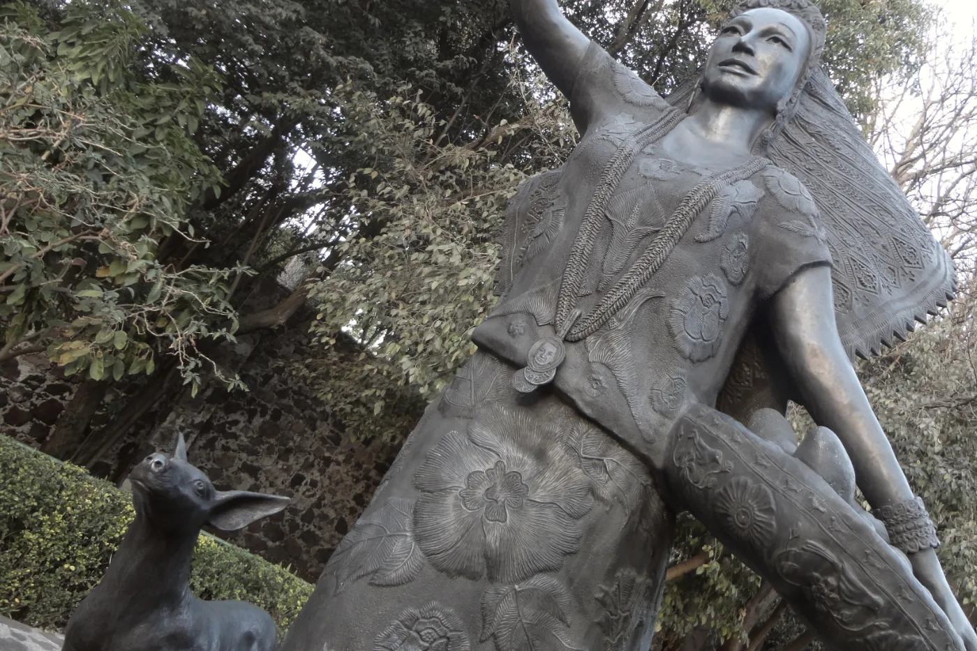 Estatua de Dolores Olmedo vestida de tehuana, con un xoloitzcuintle a sus pies, en el jardín del museo